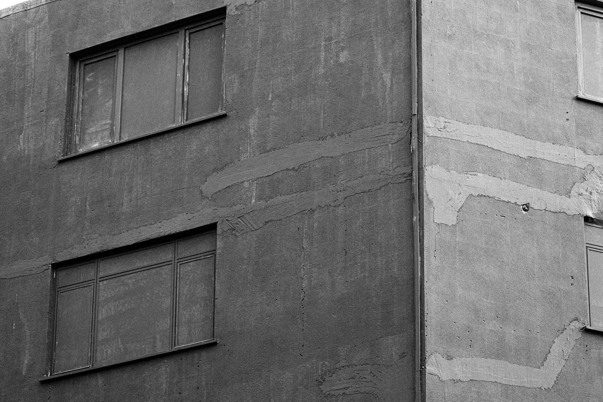 Black and white photo of a building facade showing texture and architecture details.