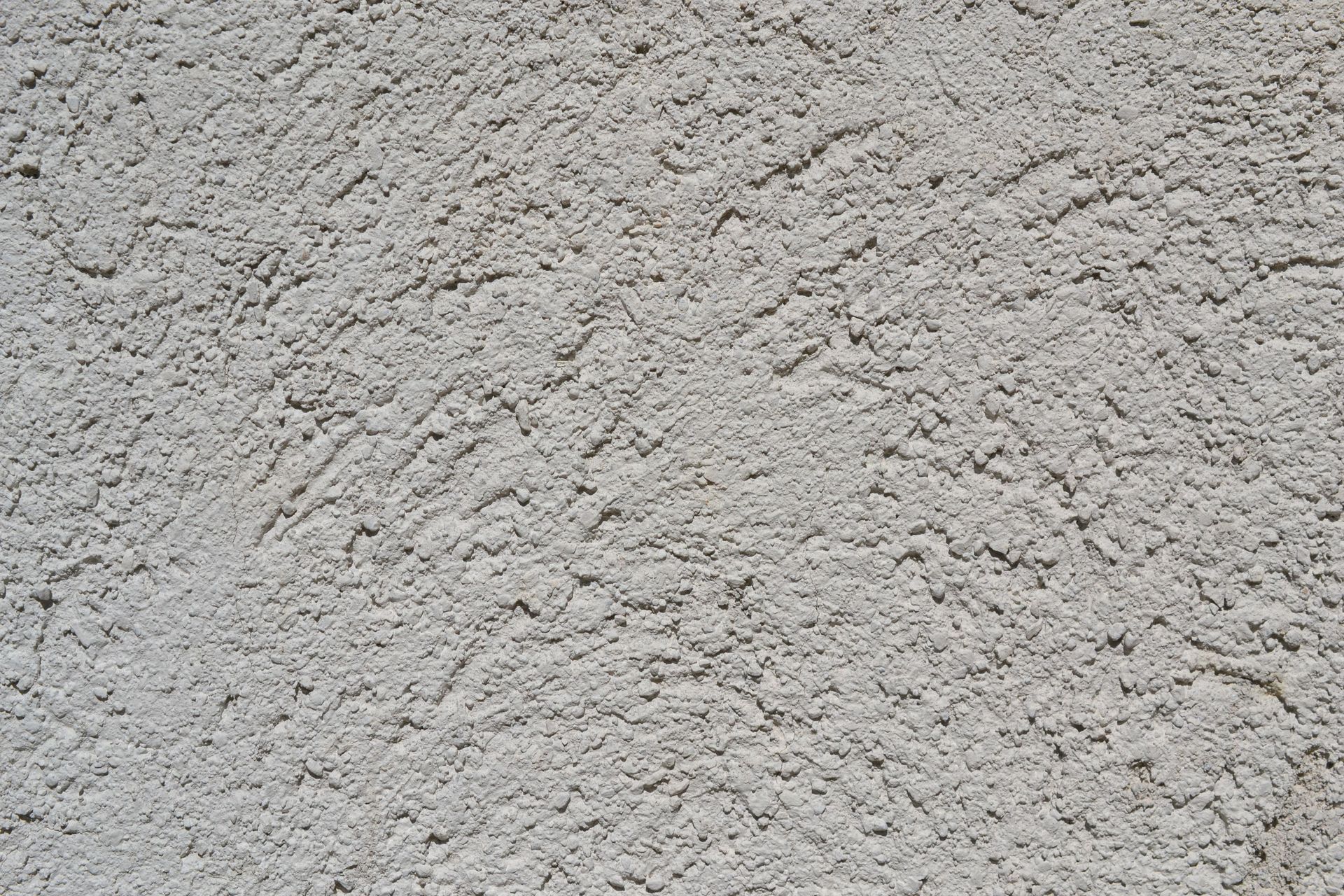 Close-up of a light gray stucco wall texture, ideal for backgrounds.